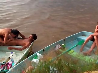 Horny people are having group sex on the beach in a small boat